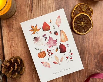 Puede incluir: Una tarjeta blanca con ilustraciones en acuarela de hojas de otoño, calabazas y bayas. La tarjeta está rodeada de decoración con temática otoñal, incluyendo una calabaza, rodajas de naranja secas y una vela encendida.