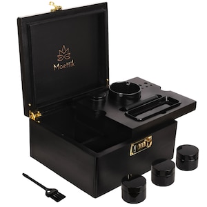 May include: A black wooden box with gold hardware, featuring an open top with a built-in tray and ashtray. The box includes three small black jars, a brush, and the text "Moettik" in gold. The box is designed for storage.