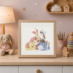 Puede incluir: Un marco de madera cuadrado que contiene una ilustración impresa de Winnie the Pooh, Piglet, Tigger y Eeyore acurrucados juntos. Los personajes están representados en un estilo de acuarela suave con colores tenues sobre un fondo claro.