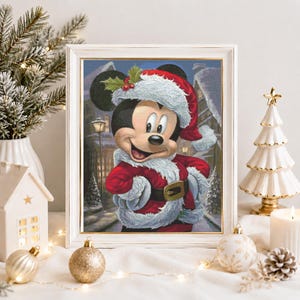 May include: A framed print featuring a cartoon mouse wearing a red and white Santa Claus suit with a matching hat, set against a snowy winter village background. The mouse has a wide smile and is centered within a white rectangular frame.