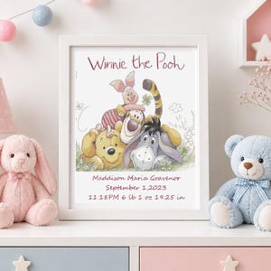 May include: A white framed print featuring a Winnie the Pooh illustration with Piglet, Tigger, and Eeyore. The text reads: Winnie the Pooh, Maddison Maria Gravenor, September 1, 2023, 11:18PM 6 lb 1 oz 19.25 in. The print is displayed on a white surface.