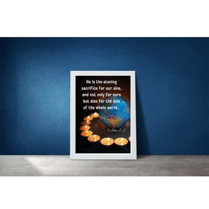 May include: A white framed print with a globe surrounded by lit candles. The text reads "He is the atoning sacrifice for our sins, and not only for ours but also for the sins of the whole world. 1 John 2:2"