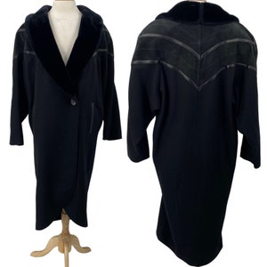 May include: A black long-sleeved coat with a faux fur collar and suede detailing on the back.
