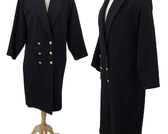 May include: A black double-breasted coat with gold-colored buttons and a wide lapel. The coat has a classic design with a long length and two front pockets. The coat is displayed on a mannequin. The coat is a timeless piece of outerwear.