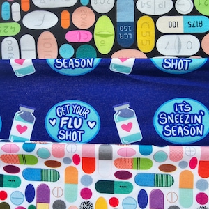May include: Three fabric panels with a repeating pattern of colorful pills and the text "Get Your Flu Shot" and "It's Sneezin' Season" on a blue background.