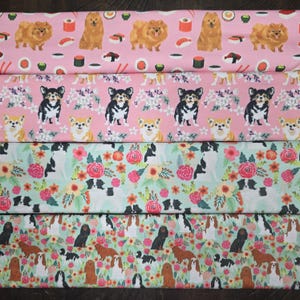May include: Fabric samples with dog-themed patterns. One pink fabric features Pomeranians and sushi. Another pink fabric has Chihuahuas. A third fabric is light green with floral and dog designs. The last fabric is light green with Cavalier King Charles Spaniels.