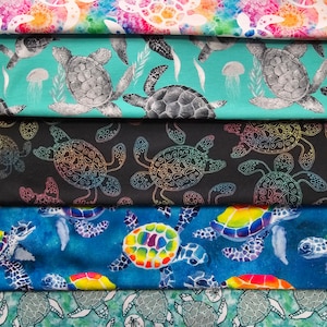 May include: Five different fabric swatches featuring a repeating pattern of sea turtles. The swatches are arranged vertically, with the top swatch featuring white sea turtles on a rainbow tie-dye background. The second swatch features gray sea turtles on a turquoise background. The third swatch features black sea turtles on a black background. The fourth swatch features rainbow sea turtles on a blue background. The fifth swatch features gray sea turtles on a green background.