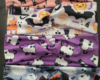 Puede incluir: Cuatro diademas con temática de Halloween con diseño de nudo retorcido. Las diademas presentan varios patrones, incluyendo gatos negros, fantasmas, murciélagos, calabazas y calaveras sobre fondos rosas, morados y grises. Accesorios ideales para Halloween.