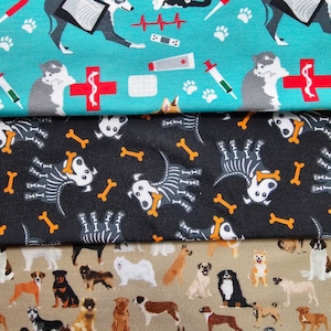 May include: Three fabric swatches with different dog-themed patterns. The top swatch is turquoise blue with white paw prints, medical symbols, and illustrations of dogs and cats. The middle swatch is black with orange bone-shaped designs and white skeletal dog illustrations. The bottom swatch is beige with brown, black, and white illustrations of various dog breeds.