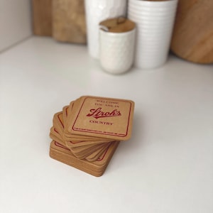 May include: A stack of brown cardboard coasters with the text "Welcome, you are in Stroh's Country" and the Stroh's logo in red.