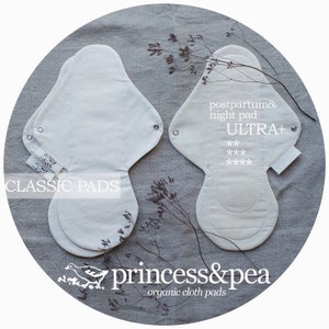 May include: Two organic cotton reusable cloth pads. One is a classic pad and the other is an ultra plus postpartum and night pad. The pads are white and have a light gray background. The text "CLASSIC PADS" is printed on the left pad. The text "postpartum & night pad ULTRA+ *** ****" is printed on the right pad. The text "princess&pea organic cloth pads" is printed below the pads.