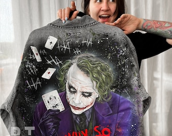 Könnte beinhalten: Eine graue Jeansjacke mit einem handgemalten Bild des Jokers aus dem Film "The Dark Knight". Der Joker hält eine Spielkarte mit der Aufschrift "Joker" und der Text "Why So Serious?" ist darunter gemalt.