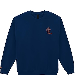 May include: A navy blue sweatshirt with a crew neck. The sweatshirt features an orange oak leaf design and the word "Clyd" in orange on the upper left chest. The letter "N" is visible on the left sleeve.