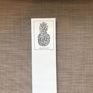 May include: A white notepad with a black pineapple illustration and the text "Hospitality" and "Ballard" at the bottom.
