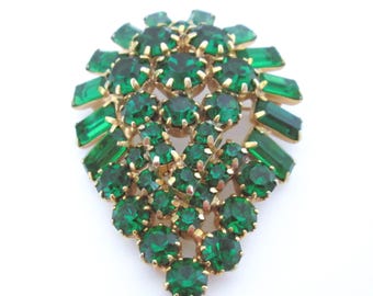 Pode incluir: Broche vintage com armação dourada, apresentando um aglomerado de strass verde esmeralda em várias formas. O broche tem um design em forma de gota, com pedras redondas e retangulares.