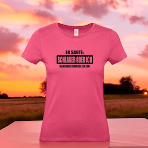 Może przedstawiać: Różowa koszulka z czarnym napisem "Er sagte: Schlager oder ich. Manchmal vermisse ich ihn!"