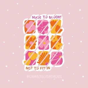 Könnte beinhalten: Ein pinkfarbener Aufkleber mit einem Raster aus neun bunten Blumen in Orange, Pink und Gelb. Der Text "MADE TO BLOOM" und "NOT TO FIT IN" ist zu sehen. Der Aufkleber hat einen pinkfarbenen Hintergrund mit weißen Punkten.
