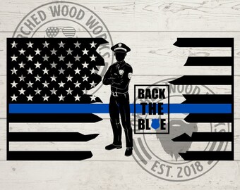 Peut inclure: Silhouette noire et blanche d'un policier debout devant un drapeau américain déchiré avec une ligne bleue. Le texte "Back the Blue" est dans une boîte noire.