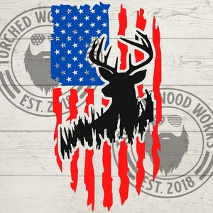 Pode incluir: Um design de bandeira americana desgastado com uma silhueta de um veado no centro. A bandeira é vermelha, branca e azul com um visual desgastado. O veado é preto e tem grandes chifres.