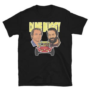 Puede incluir: Camiseta negra con un gráfico de dos hombres y un buggy rojo. El texto "Dune Buggy" es amarillo. El buggy tiene una barra antivuelco amarilla y la palabra "Puma" en la parte delantera.