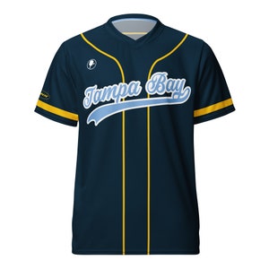 May include: A navy blue baseball jersey with yellow accents and the text "Tampa Bay" in a blue and white script font.