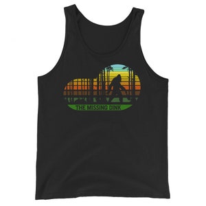May include: Black tank top with a retro-style graphic of Bigfoot walking through a forest with a sunset in the background. The text "THE MISSING DINK" is below the graphic.