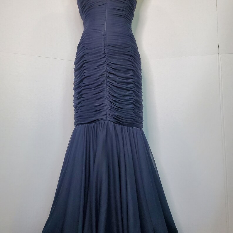 May include: A dark blue, floor-length, strapless gown with a fitted bodice and a flowing skirt.