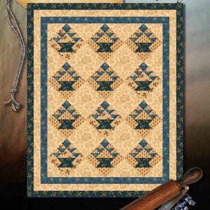 Pode incluir: Padrão de colcha Blueberry Crumb Cake da Wagons West Designs. A colcha apresenta um design de cesta em um esquema de cores azul e creme. A colcha mede 60 cm x 74 cm.