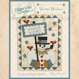 Pode incluir: Um padrão de aplique de feltro para um boneco de neve segurando um sinal que diz "Winter Wishes". O padrão é cercado por um design de colcha de retalhos com estrelas e triângulos. O padrão mede 14 polegadas por 18 polegadas.