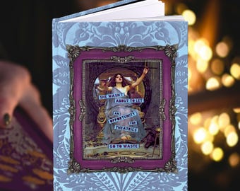 May include: Hardcover journal with a decorative cover featuring a vintage illustration of a woman in a purple frame. The journal has a light blue patterned background and the text "SHE WASN'T ABOUT TO LET AN OPPORTUNITY FOR THEATRICS GO TO WASTE."