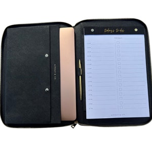 May include: Black leather zipped portfolio with a gold zipper and a notepad with a to-do list. The notepad has the text "today's to-dos" and "TODAY:" printed on it. The portfolio has a pocket for a laptop and a pen holder.