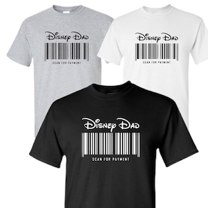 May include: Three t-shirts with the text "Disney Dad" and a barcode underneath. The text "Scan for Payment" is below the barcode. The t-shirts are in grey, white, and black.