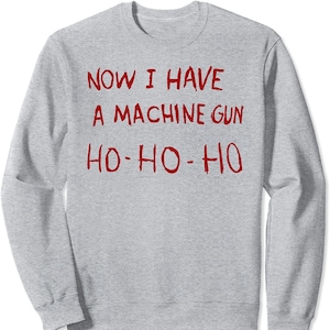 May include: Gray sweatshirt with red text that reads "Now I have a machine gun Ho-Ho-Ho".