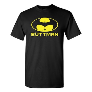 May include: Black t-shirt with a yellow graphic of a stylized bat with the text "BUTTMAN" underneath.