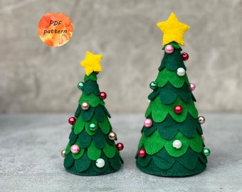 Könnte beinhalten: Zwei Filz-Weihnachtsbäume, einer grün und einer kleiner grün, mit gelben Sternentoppern und mit roten, rosa und weißen Perlen verziert. PDF-Muster.