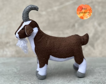 May include: A brown and white felt goat with a gray horn and a white beard. The goat is standing on a gray surface. PDF pattern.