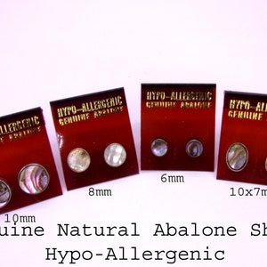 May include: Four pairs of hypoallergenic abalone shell earrings in different sizes: 10mm, 8mm, 6mm, and 10mm by 7mm. The earrings are displayed on red cards with gold lettering that reads "Hypo-Allergenic Genuine Abalone".