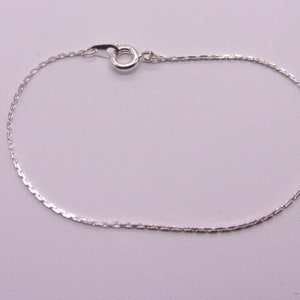 May include: A silver chain bracelet with a lobster clasp.