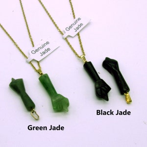 May include: Three jade necklaces with pendants shaped like fists. The necklaces are on a white background. The pendants are labeled "Green Jade", "Black Jade", and "Genuine Jade".