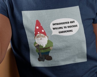 Peut inclure: T-shirt bleu marine avec un gnome de dessin animé portant un chapeau rouge et le texte "INTROVERTED BUT WILLING TO DISCUSS GARDENING" dans une bulle. Le gnome tient une pelle. Vêtement décontracté.