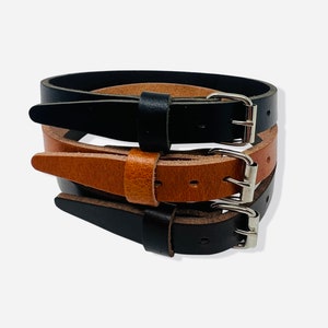 Leather utility strap made from old English buffalo leather. Fitted with a 3/4” roller buckle.