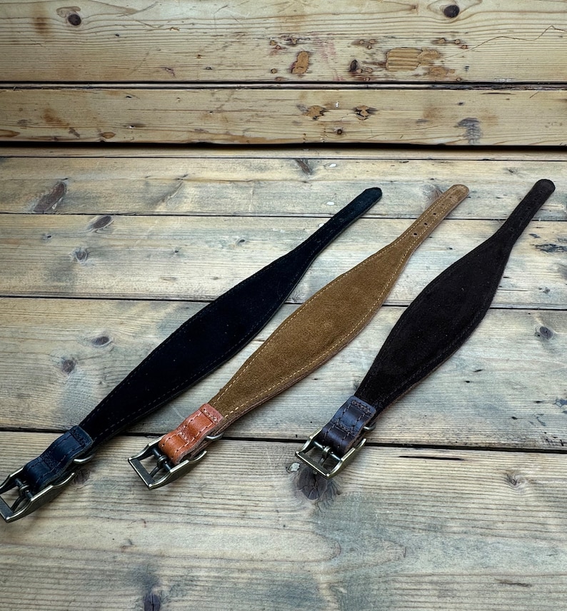 May include: Three leather dog collars in black, brown, and tan. The collars are made of suede and have a buckle closure.