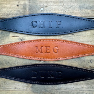 May include: Three leather dog collars with the names "CHIP", "MEG", and "DUKE" embossed on them.