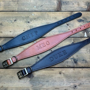 May include: Three leather dog collars with personalized names: Chip, Meg, and Duke. The collars are black, brown, and dark brown.