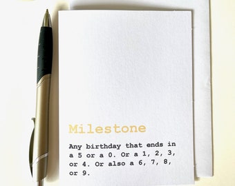May include: A white card with the word "Milestone" in yellow text. The card defines a milestone as "Any birthday that ends in a 5 or a 0. Or a 1, 2, 3, or 4. Or also a 6, 7, 8, or 9."