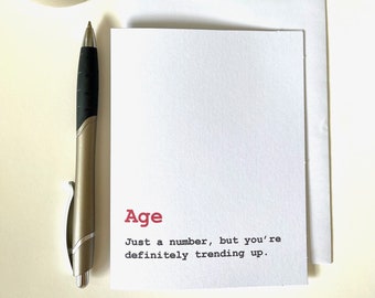 May include: A white card with the word "Age" in red text. The card reads "Just a number, but you're definitely trending up."