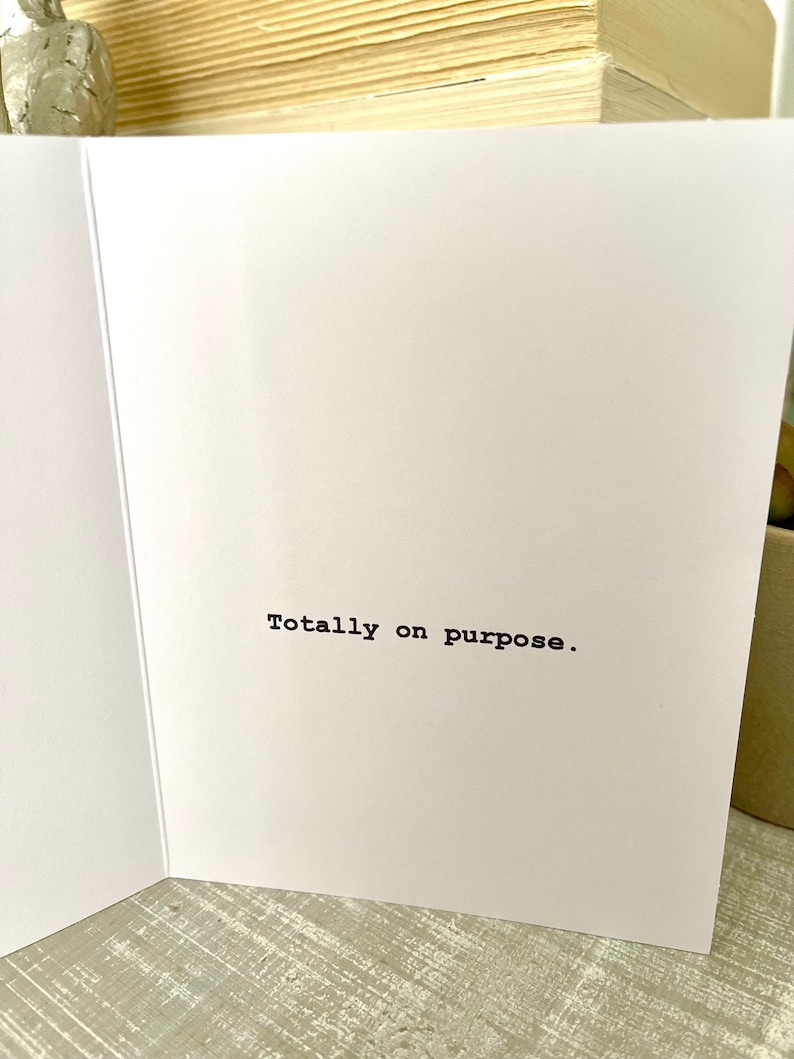 May include: A white card with the text "Totally on purpose." printed in black.