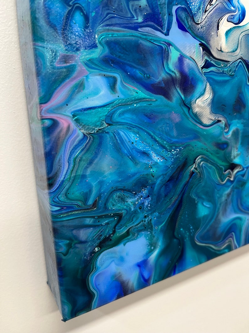 May include: Abstract painting with swirling blue, teal, and white paint. The colors blend together to create a dynamic and fluid design.