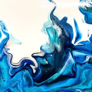 May include: Abstract painting with swirling blue, white, and turquoise paint. The colors blend together to create a dynamic and fluid design.