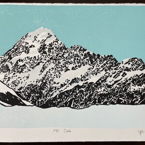 May include: A black and white woodcut print of Mount Cook, a snow-capped mountain range in New Zealand. The print is numbered 13/50 and signed "c.y.c. 2022".